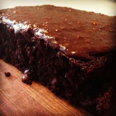 a piece of chocolate cake sitting on top of a wooden cutting board