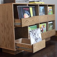 a wooden book shelf filled with books on top of a hard wood floor