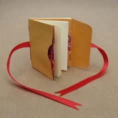 an open book with a red ribbon around it