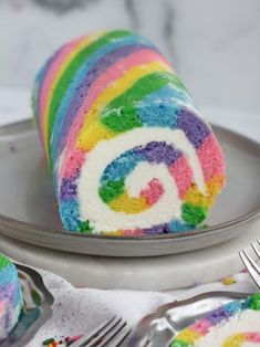 a rainbow swirl cake on a plate with a fork