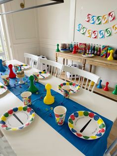 the table is set with plates, cups and spoons for children's birthday party