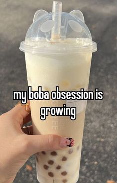 someone holding up a drink with the caption my boba possession is growing