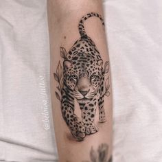 a black and white tattoo of a leopard on the arm