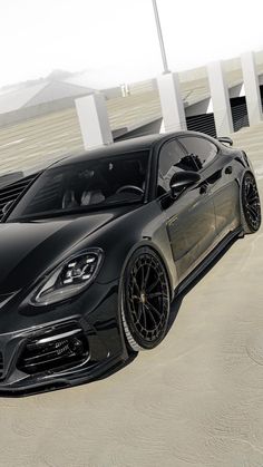 a black sports car parked in an empty parking lot