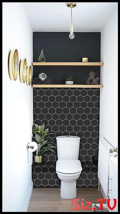 a white toilet sitting in a bathroom next to a wooden shelf filled with potted plants