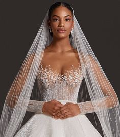 a woman in a wedding dress with a veil on her head and hands folded over her chest