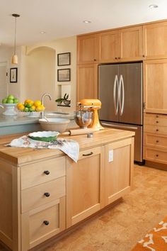 a large kitchen with wooden cabinets and an island in the middle is shown, along with other appliances