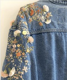 the back of a jean jacket with flowers on it