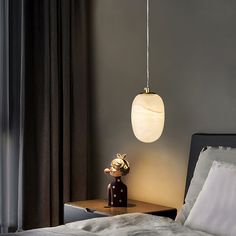 a bedroom with a bed, nightstand and lamp in the corner on top of it