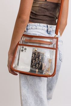 The Crystal Clear Carry-All Messenger Bag is perfect for your on-the-go needs. Keep your belongings safe and organized in this stylish and transparent bag. With its clear design, you'll never have to search for your items again. Stay chic and trendy with this fun and happy bag! #lovemyleto 100% PVC Imported Happy Bag, Earthy Chic, Kimono Sweater, Transparent Bag, Bralette Tops, Top Graphic Tees, Guitar Strap, Kimono Dress, Tank Top Cami