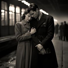 a man and woman standing next to each other in front of a train station platform