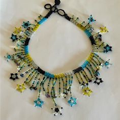 a necklace made with beads and scissors on a white tablecloth covered surface in the shape of stars