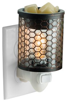 a light that is on the side of a white wall mounted holder with some candles in it