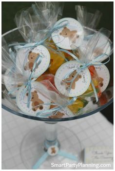 a clear glass bowl filled with lots of candies and teddy bears on top of it