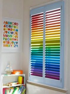 colorful blinds in the corner of a room with bookshelf and toys on it