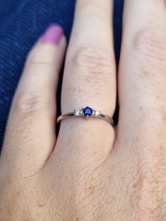 a woman's hand with a ring on it that has two stones in the middle