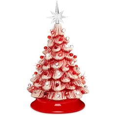 a glass christmas tree with red and white ornaments on the top, in front of a white background