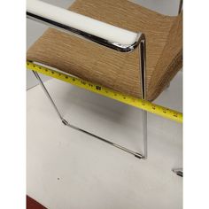 a chair with a tape measure in front of it and the seat upholstered