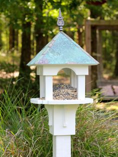 a bird feeder in the middle of some grass