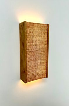 a wooden light fixture mounted to the side of a wall next to a white wall