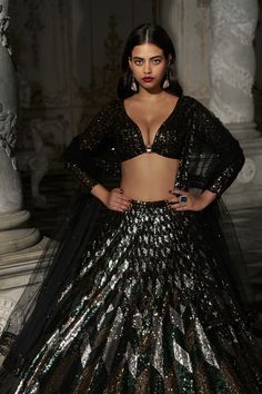 This lehenga set features sequin embroidery in emerald green, antique gold and antique silver in a chevron pattern. It is paired with a full sleeves blouse and a matching dupatta with border on all four sides.From Seema Gujral's Inara collection. DELIVERY TIMEPlease allow 8-12 weeks for your outfit to arrive. FABRIC DETAILSNet Professional cleaning only. Festive Lehenga With Sequins For Party, Festive Party Lehenga With Sequins, Glamorous Semi-stitched Sequined Choli, Glamorous Green Lehenga, Glamorous Green Lehenga For Party, Glamorous Sequined Sharara For Navratri, Festive Glamorous Lehenga With Sequins, Glamorous Festive Lehenga With Sequins, Glamorous Festive Lehenga With Unstitched Blouse