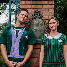 two people standing in front of a brick sign