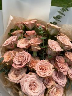 a bouquet of pink roses sitting on top of a table