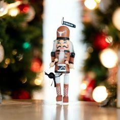 a toy soldier is standing in front of a christmas tree