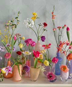 there are many different vases with flowers in them