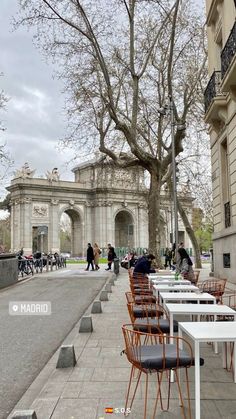 tables and chairs are lined up on the side walk in front of an old building