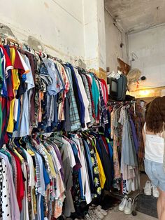 there is a woman looking at shirts on display