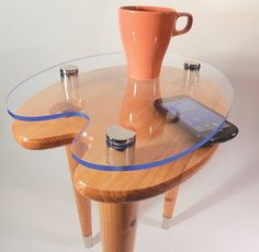 a table with a cell phone on it and a cup sitting on top of it