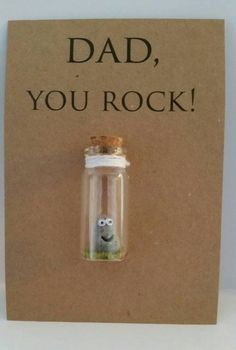 a card with an image of a glass bottle containing a small cartoon character, dad you rock