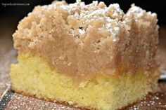 a piece of yellow cake sitting on top of a wooden table next to a fork