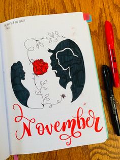 an open notebook with the words november written on it next to a pen and marker