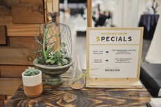 there is a sign that says wedding show specials on the table next to two vases with succulents in them