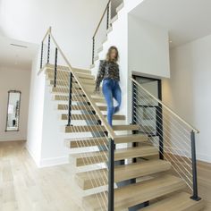 a woman is walking down the stairs in a house