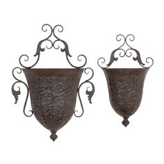 two metal vases with ornate designs on them, one is hanging from the wall