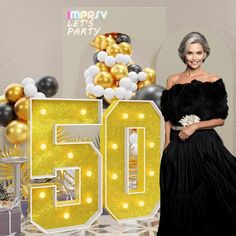 a woman standing in front of a 50th birthday sign