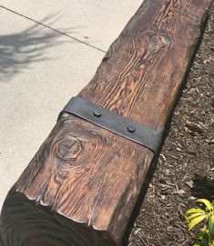 a wooden bench sitting on top of a sidewalk