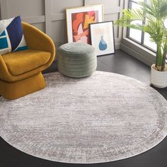 a round rug in a living room with two chairs and a potted plant on the floor