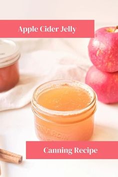 an apple cider jelly in a glass jar next to cinnamon sticks and two apples