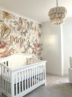 a baby's room with floral wallpaper and white crib