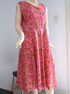 "VINTAGE 1970s HOME SEWN  Fit + Flare PINK FLORAL dress in a size Large to Extra Large.   Super soft and light fabric in an all over floral pattern in pinks, oranges, browns and white.   V-Neck and Back with a 9.5\" partial metal side zipper.  Perfect frock with pleats on the skirt ideal for some dancing and cocktails!! Measurements laying flat: -across the top 16\" -across the bust  20\" -across the waist  17.5\"  -shoulder to waist 16\" -across shoulder strap 3 1/8\" -top to bottom 42.5\" Stalk us on instagram: @outofthepastclothing Stay in touch through FACEBOOK: outofthepastclothing Thousands of stylish and satisfied customers served since 1993. Questions?  Just ask us! And thanks very much for taking the time to visit our listings!" Vintage Pink A-line Dress, Pink Floral Print Vintage Dress, Vintage Pink Dress For Garden Party, Retro Pink Vintage Dress With Floral Print, Pink Retro Vintage Dress With Floral Print, Pink Retro Dresses For Daywear, Retro Pink Vintage Dress For Garden Party, Spring Sleeveless Pink Vintage Dress, Pink Sleeveless Vintage Dress For Spring