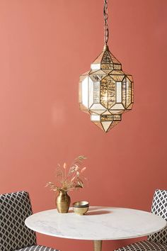 a dining room table with chairs and a chandelier hanging from the ceiling