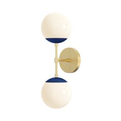 two white and blue balls hanging from a brass wall light with one ball on the opposite side