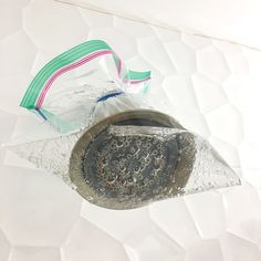 a piece of metal sitting on top of a white surface next to a plastic bag