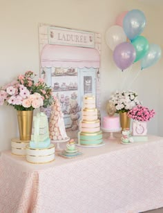 a table topped with lots of cakes and flowers