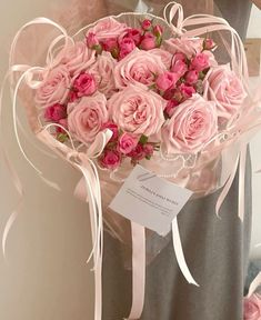 a woman holding a bouquet of pink roses in her hands with a price tag on it