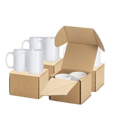 four white coffee mugs in a cardboard box with one open and the other empty